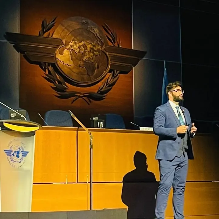 Dan Sloat delivering a keynote on the ICAO Assembly Hall stage in front of the ICAO emblem